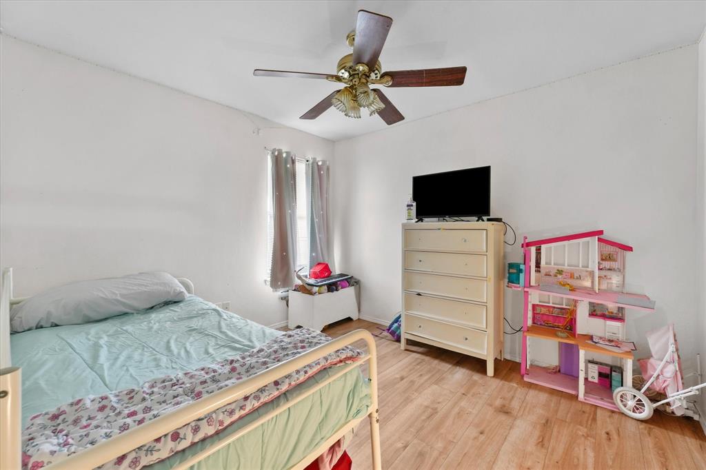 6725 Prairie Fire Road Arlington, TX 76002 - Photo 22 of 31 a bedroom with a bed and a flat tv screen on the dresser