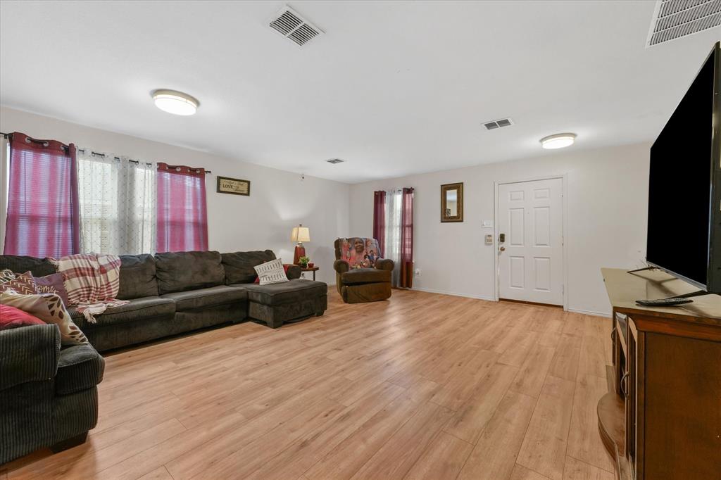 6725 Prairie Fire Road Arlington, TX 76002 - Photo 7 of 31 a living room with furniture and a flat screen tv