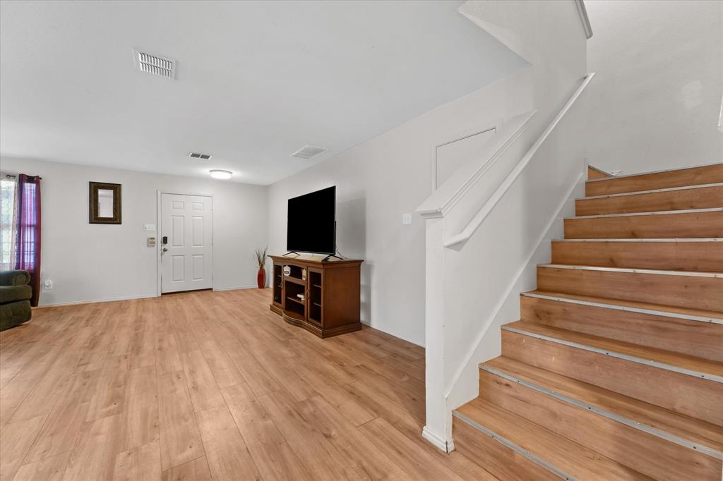 6725 Prairie Fire Road Arlington, TX 76002 - Photo 8 of 31 a room with stairs and a flat screen tv