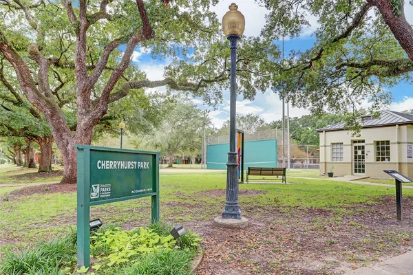 a sign board with a big yard and large trees