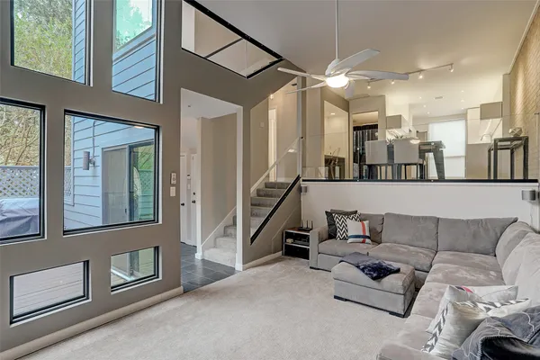 a living room with furniture and a ceiling fan