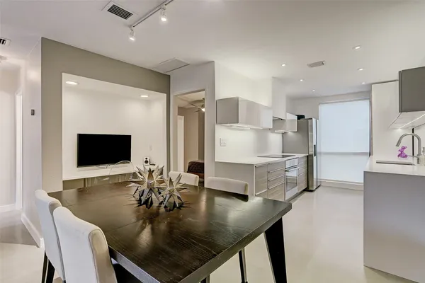 a living room with stainless steel appliances kitchen island granite countertop furniture and a flat screen tv