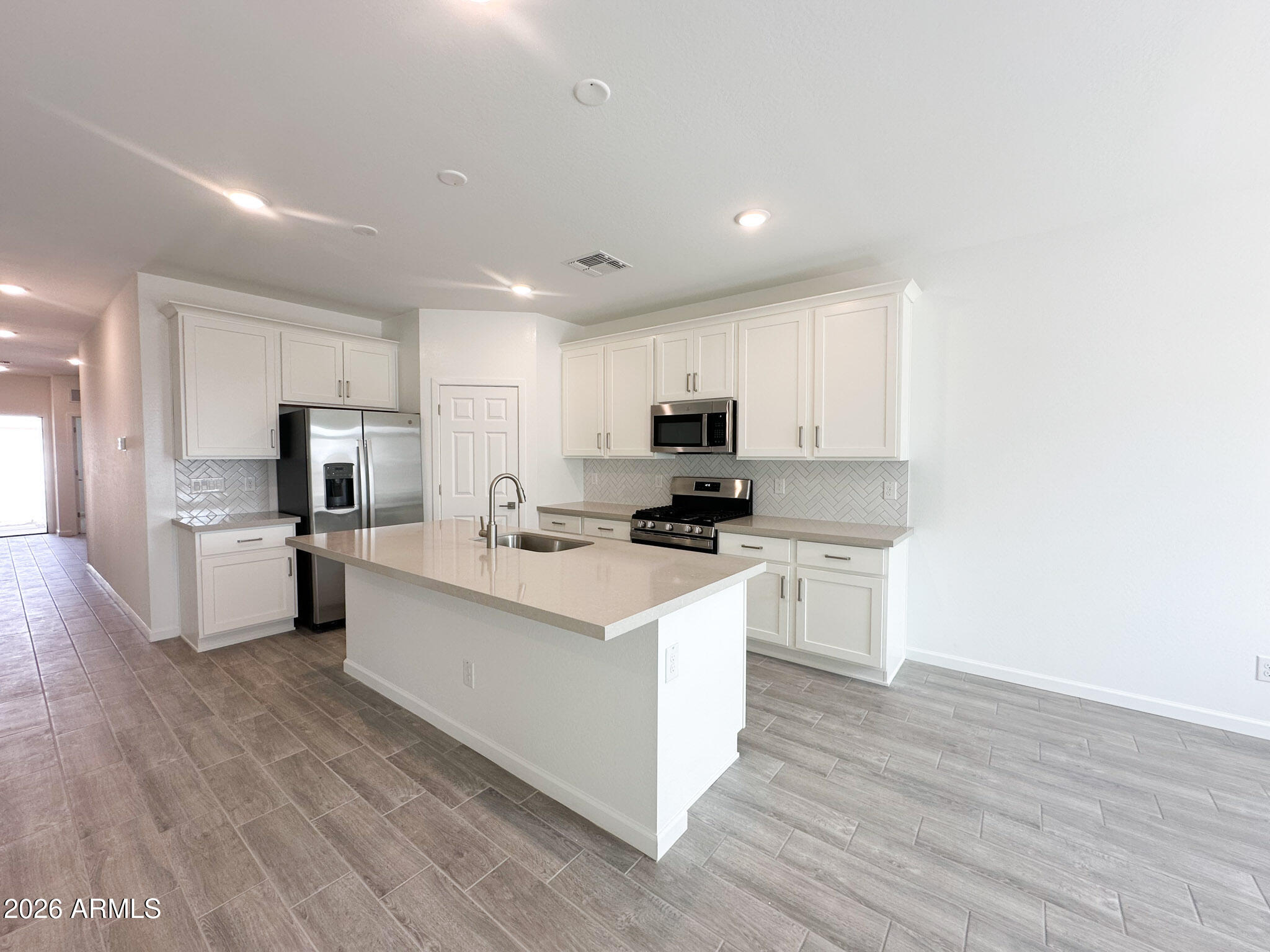 47637 West Moeller Road Maricopa, AZ 85139 - Photo 3 of 19 a kitchen with white cabinets and stainless steel appliances