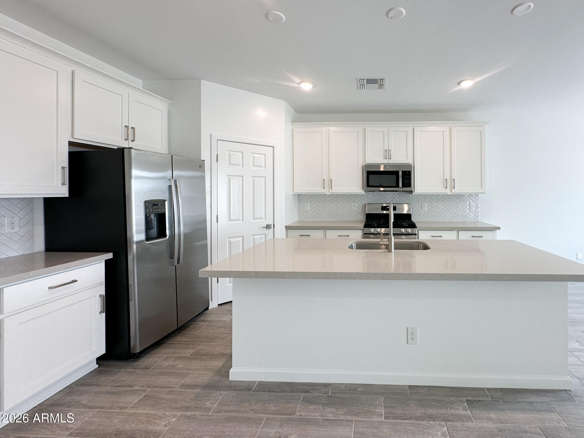 47637 West Moeller Road Maricopa, AZ 85139 - Photo 4 of 19 a kitchen with stainless steel appliances a refrigerator a sink a stove a microwave and cabinets