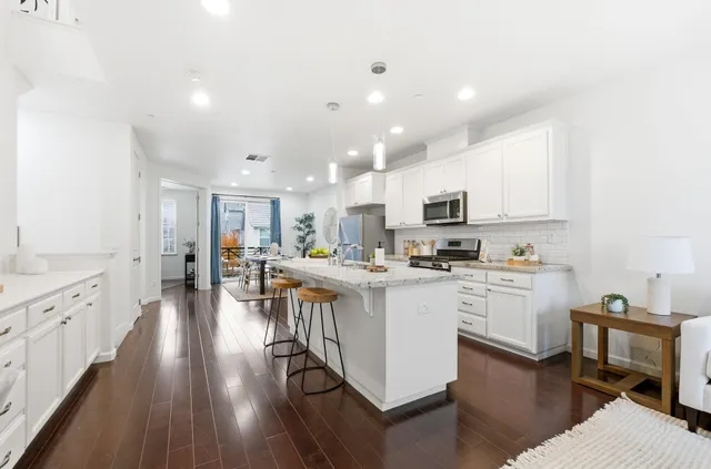 a kitchen with white cabinets stove and sink