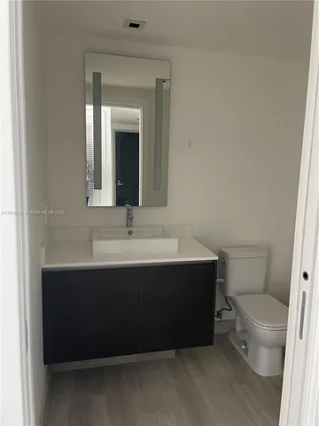 a bathroom with a sink vanity mirror and toilet