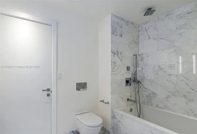 a bathroom with a shower a toilet and a shower