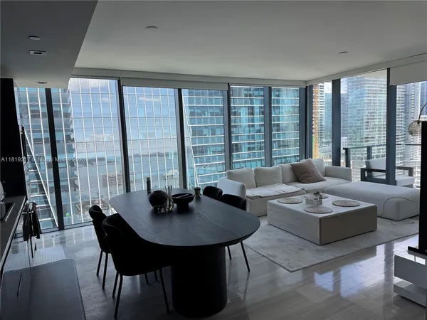 a living room with furniture and a floor to ceiling window