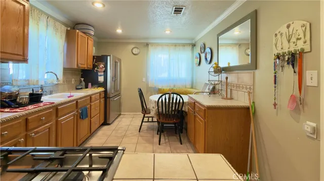 a kitchen with stainless steel appliances kitchen island granite countertop furniture and a refrigerator