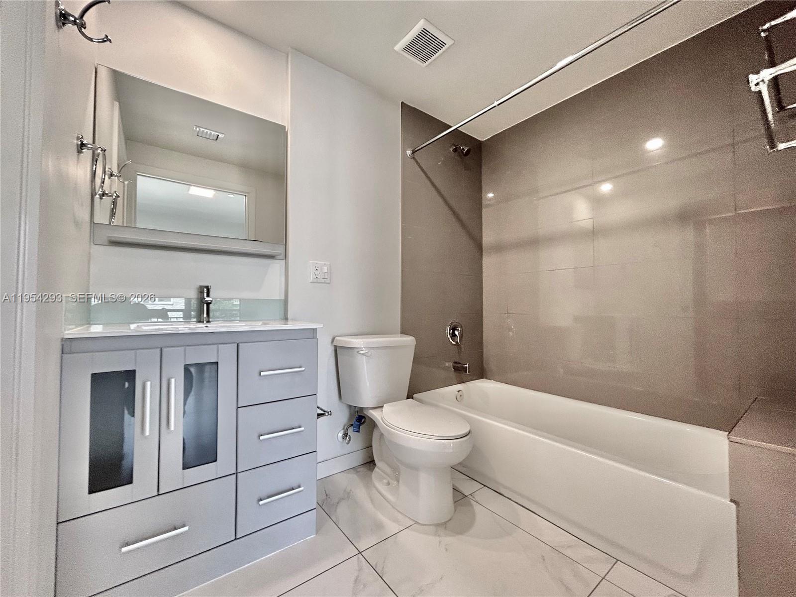 836 Southwest 2nd Street, Unit 202 Miami, FL 33130 - Photo 22 of 36 a bathroom with a granite countertop toilet sink and mirror