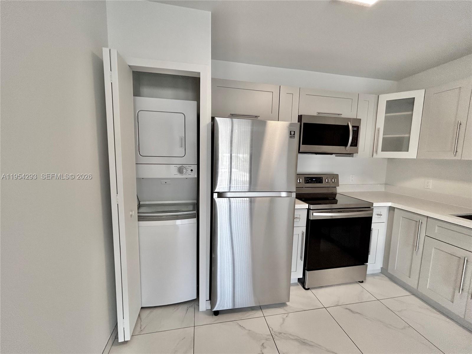 836 Southwest 2nd Street, Unit 202 Miami, FL 33130 - Photo 4 of 36 a kitchen with stainless steel appliances a refrigerator stove microwave and sink