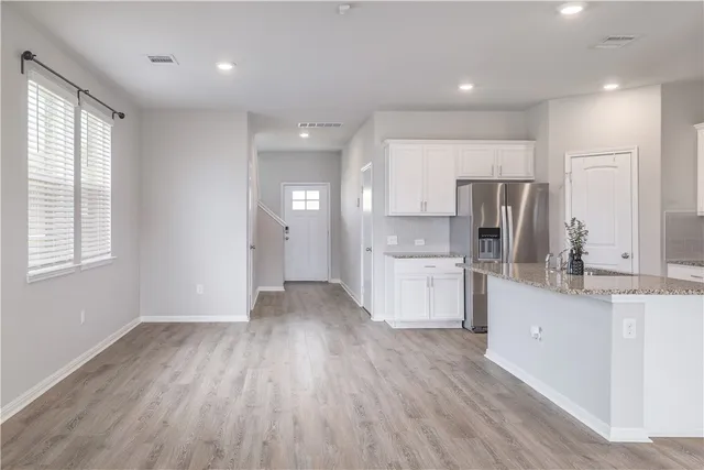 a kitchen with white cabinets and stainless steel appliances