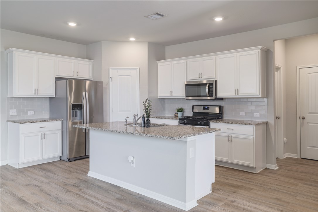 445 Shiner Lane Georgetown, TX 78626 - Photo 12 of 35 a kitchen with stainless steel appliances granite countertop a refrigerator stove microwave and sink