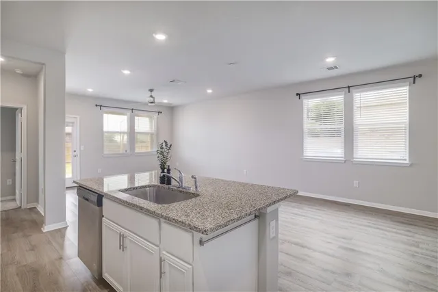 a kitchen with granite countertop a sink and a wooden floor