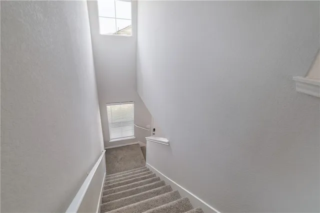 a view of a hallway with wooden floor and a bathroom