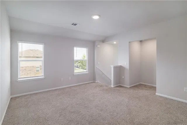 an empty room with windows and closet