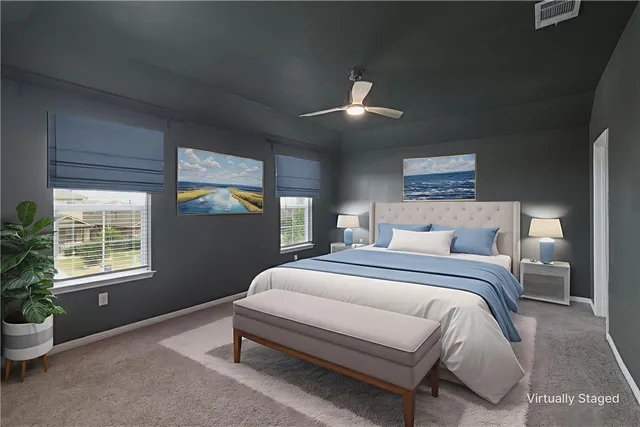 a bedroom with a large bed and windows