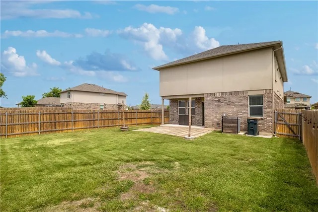a view of a backyard with table and chairs and wooden fence