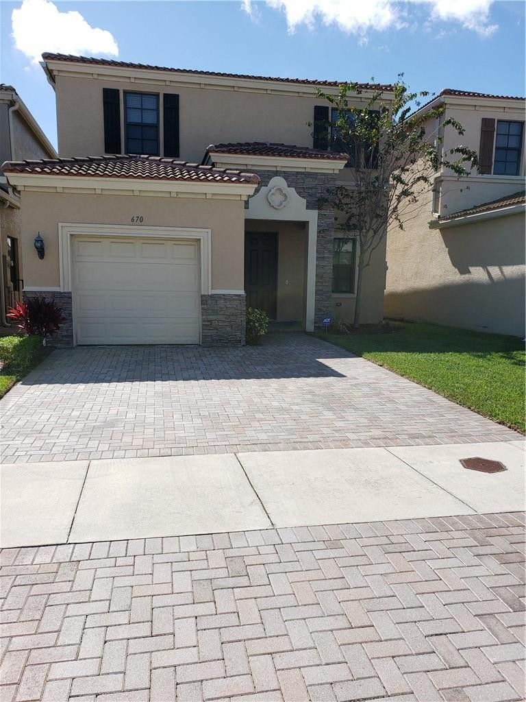 a view of a white house with a sink and dishwasher in front of it