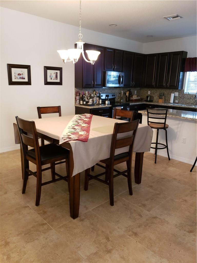 Undisclosed Address Miami, FL 33179 - Photo 4 of 24 a kitchen with a table chairs sink and cabinets