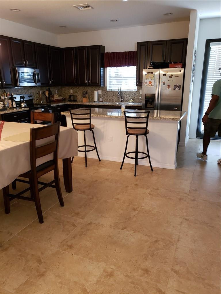 Undisclosed Address Miami, FL 33179 - Photo 5 of 24 a view of kitchen with stainless steel appliances wooden floor dining table and chairs