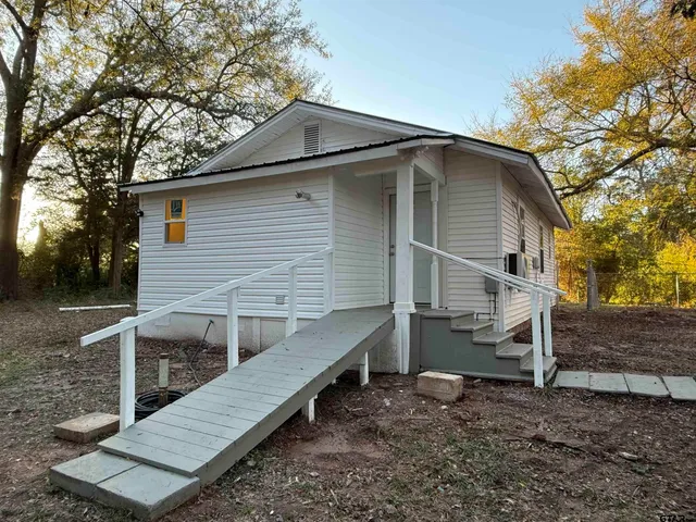 a view of a house with a yard and wooden fence