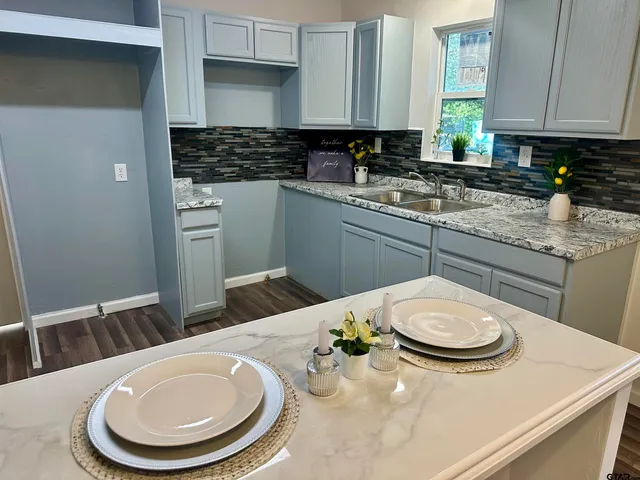 a kitchen with a sink a stove and chairs