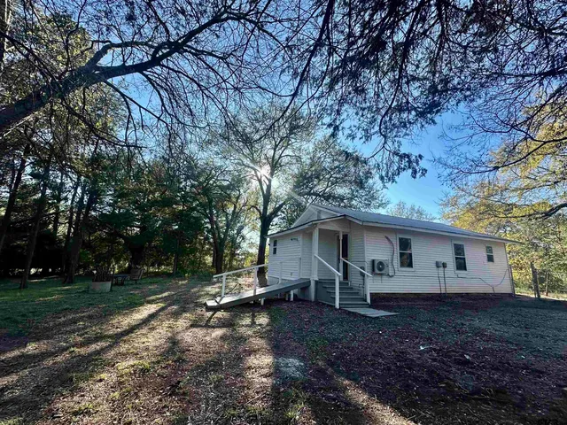 a view of a house with backyard and trees