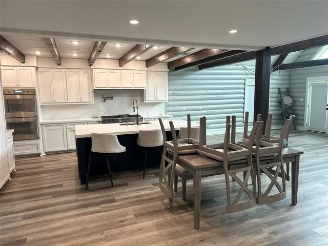 a kitchen with kitchen island granite countertop a sink and wooden floor