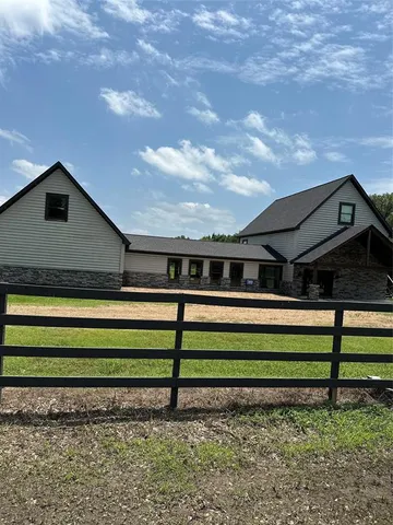 a front view of a house with yard and green space