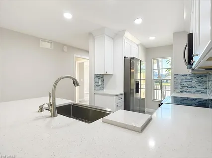 a kitchen with stainless steel appliances a refrigerator sink and cabinets