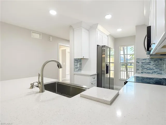 a kitchen with stainless steel appliances a refrigerator sink and cabinets