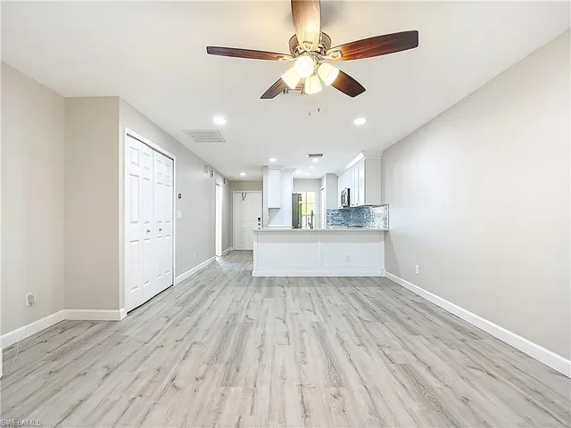 a view of a kitchen with wooden floor and a ceiling fan