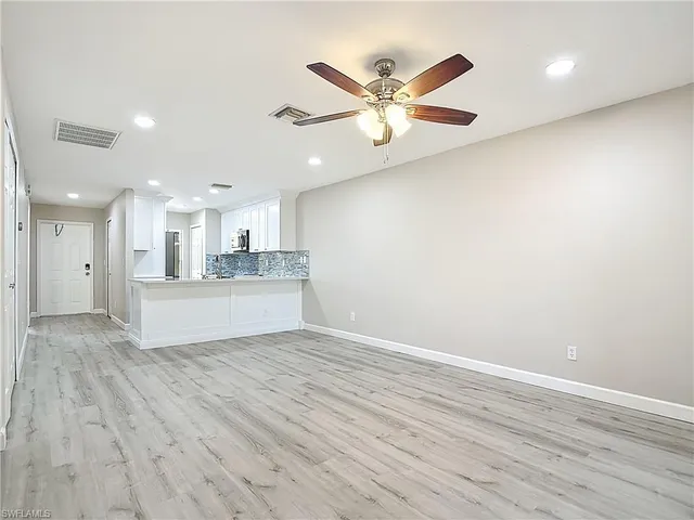 a view of a kitchen with wooden floor and a ceiling fan