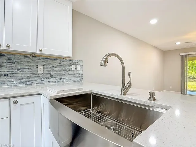 a kitchen with granite countertop a sink and a stove top oven