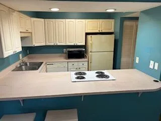 a kitchen with a sink a stove and white cabinets