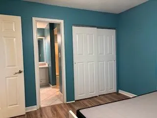 an empty room with wooden floor and closet