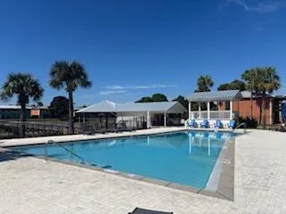 a front view of a house with swimming pool having outdoor seating