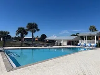 a view of a house with pool and chairs