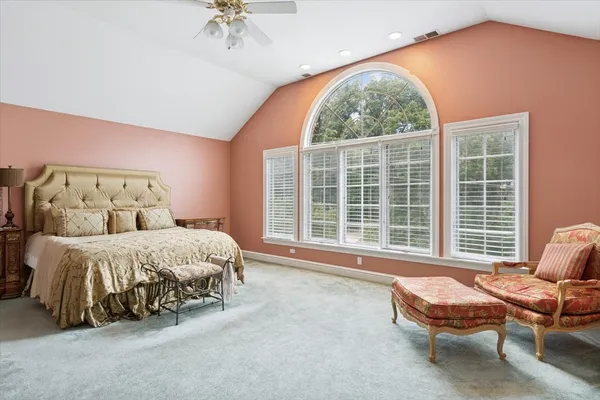 a spacious bedroom with a bed and a window