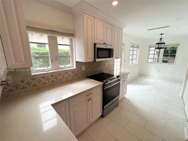 a kitchen with stainless steel appliances granite countertop a stove a sink and a microwave