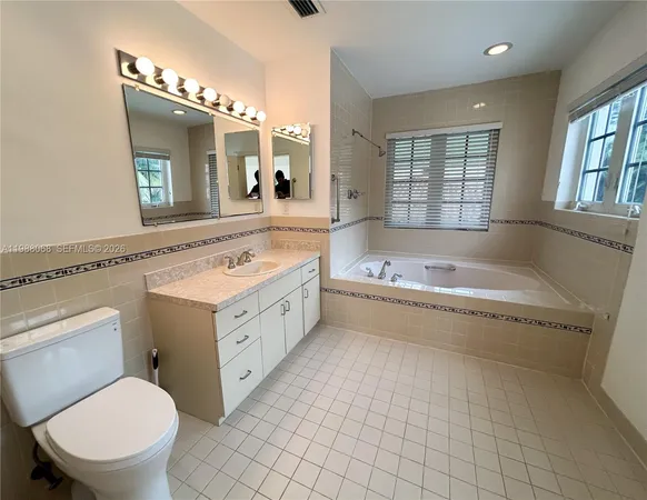 a bathroom with a tub a sink and a large window