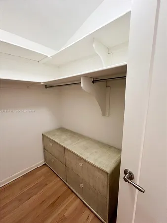 an empty room with wooden floor ceiling fan and windows