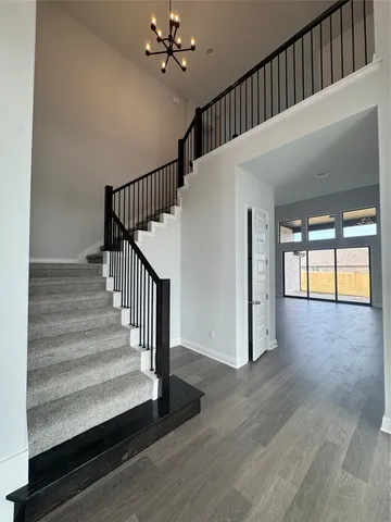 a view of staircase with wooden floor and fan