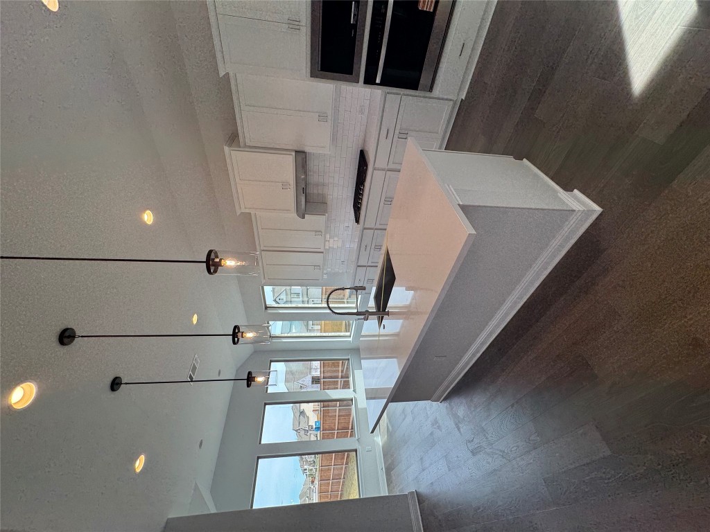 232 Camille Street Leander, TX 78641 - Photo 3 of 26 a large kitchen with kitchen island a large counter top a stove a sink and a wooden floors