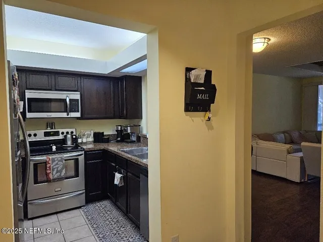 a kitchen with stainless steel appliances granite countertop a refrigerator and a stove top oven