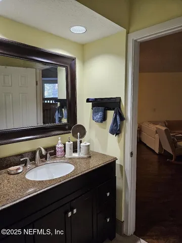 a bathroom with a granite countertop sink and a mirror