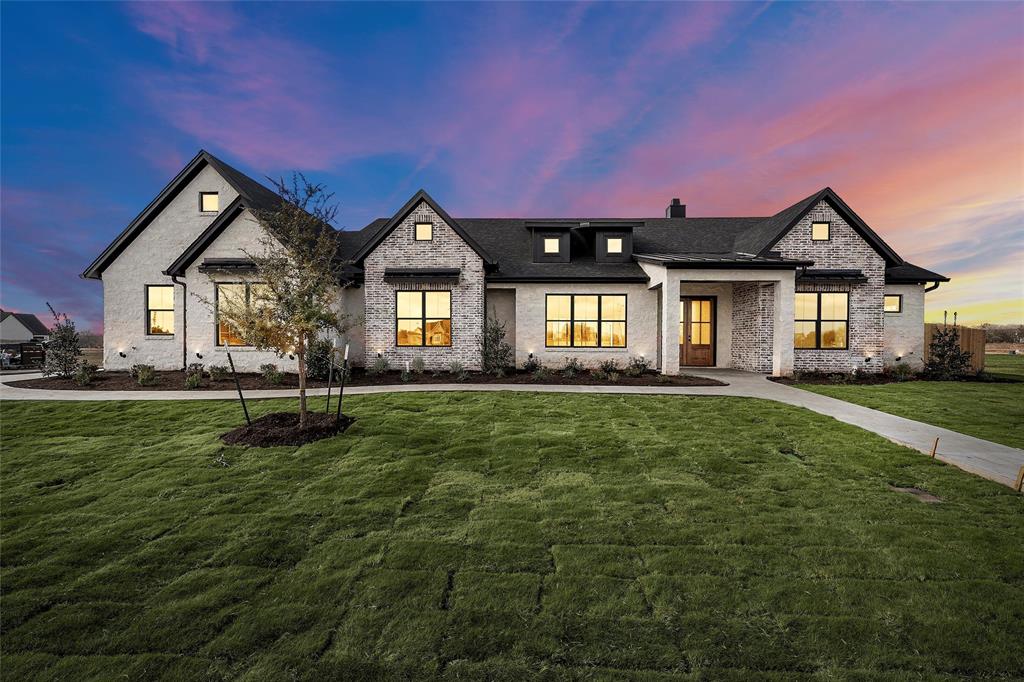 a front view of a house with a garden and yard