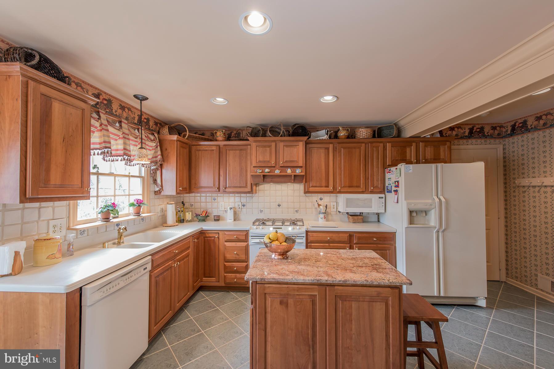 3677 Meadowvale Road Ellicott City, MD 21042 - Photo 12 of 30 a kitchen with a sink a refrigerator and cabinets
