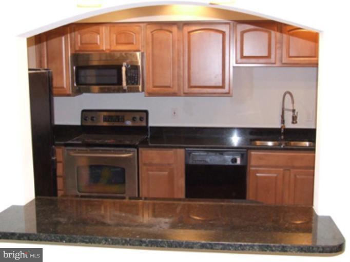 a kitchen with stainless steel appliances a stove a microwave and a sink